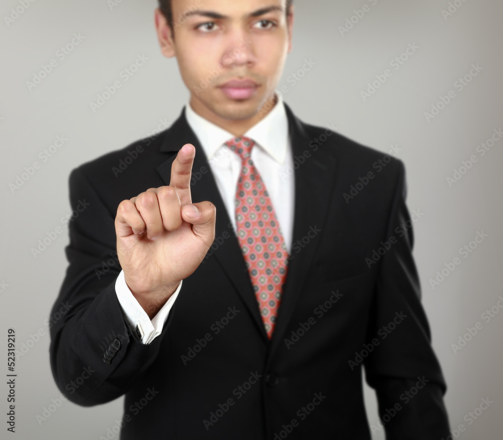 A businessman showing something isolated on grey background A businessman showing something isolated on grey background