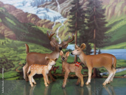Modellrehe und -hirsch vor Alpenlandschaft