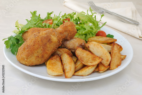 Chicken drumsticks with breadcrumbs with potatoes and salad