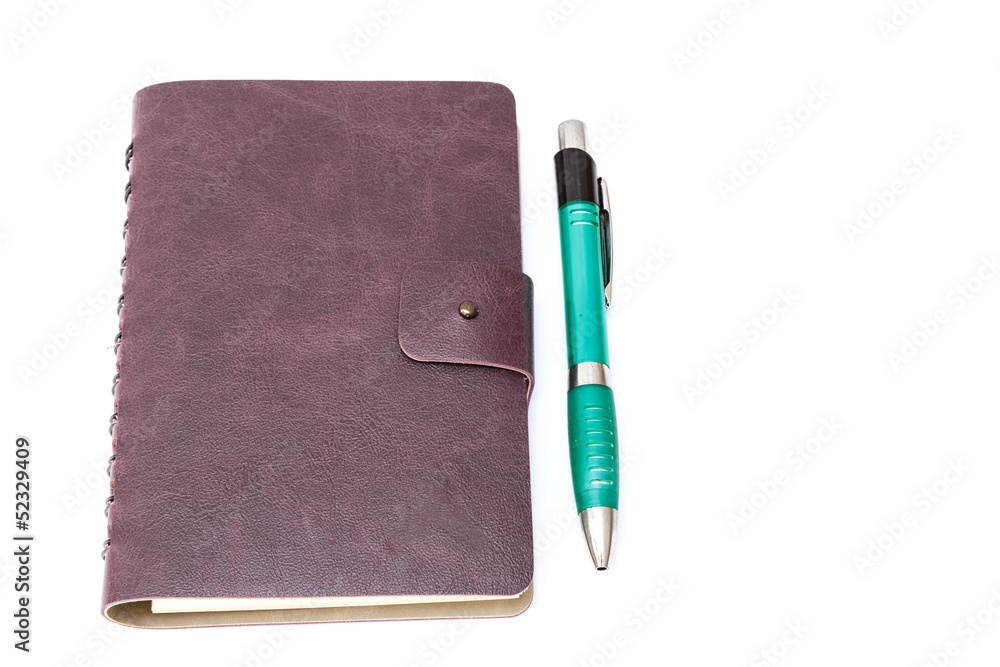 Leather cover of violet notebook with pen on table background Leather cover of violet notebook with pen on table background