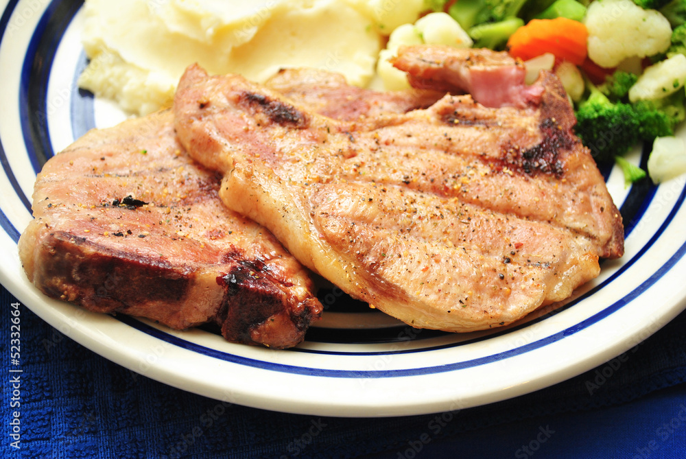 Two Pork Chops Served on a Plate Two Pork Chops Served on a Plate
