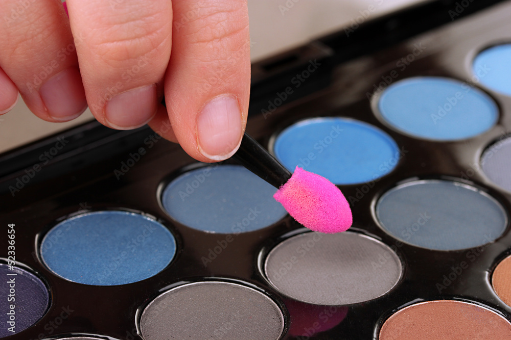 Bright eye shadows and sponge brushes for foundation close up Bright eye shadows and sponge brushes for foundation close up