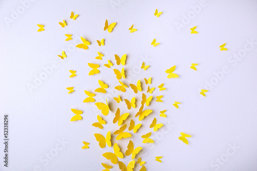 Paper yellow butterflies fly on wall in different directions