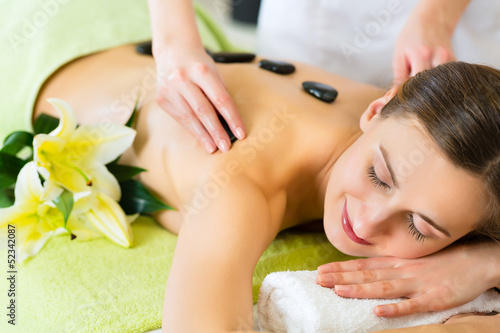 woman having wellness hot stone massage