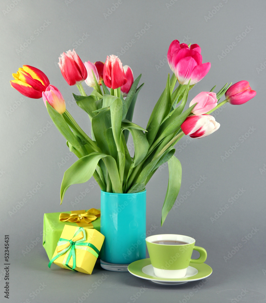 Fototapeta premium Beautiful tulips in bucket with gifts and cup of tea