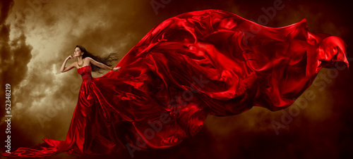 Woman in red waving beautiful dress with flying fabric