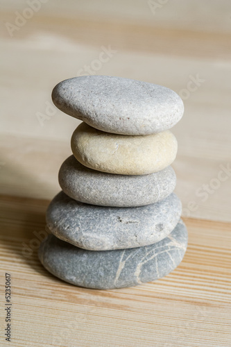 Canvas Print Five spa zen stones stacked on a wood background