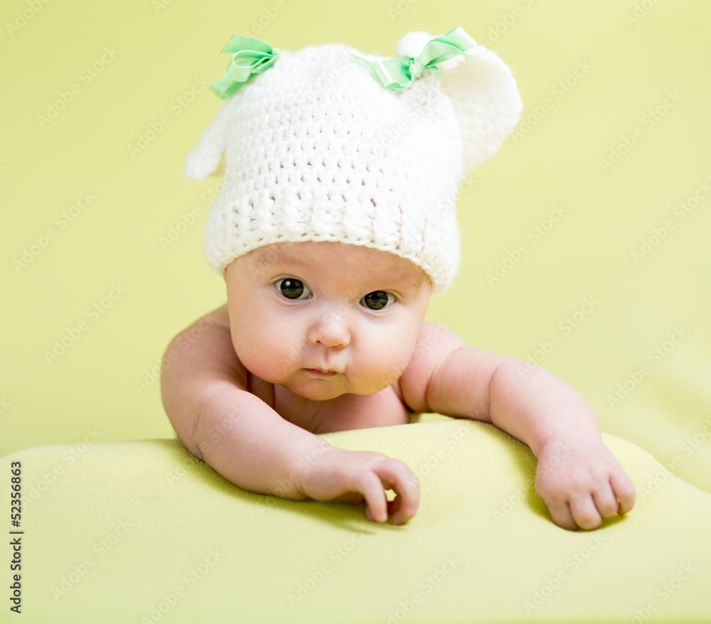 baby girl is lying on green bed baby girl is lying on green bed