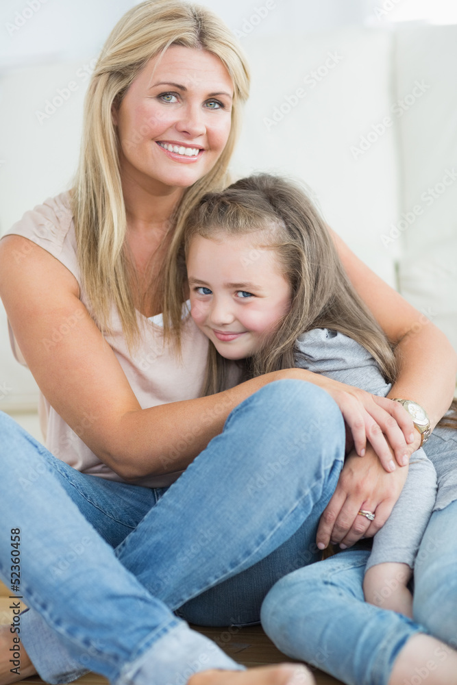 Mother and daughter hugging in living room Mother and daughter hugging in living room