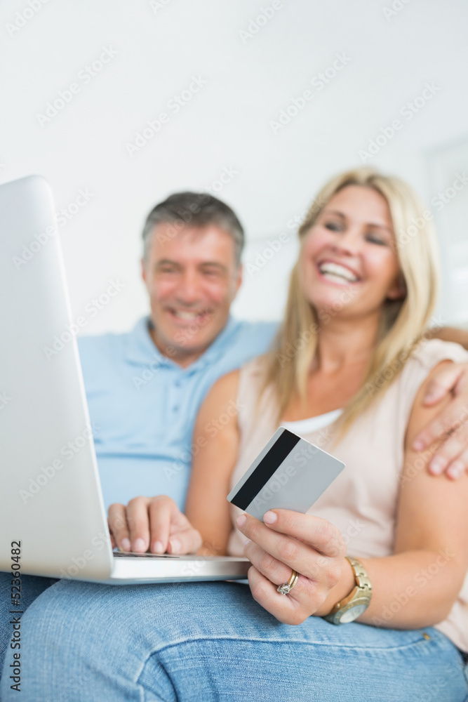 Couple sitting on sofa shopping online Couple sitting on sofa shopping online