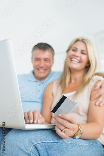 Couple sitting on sofa shopping online