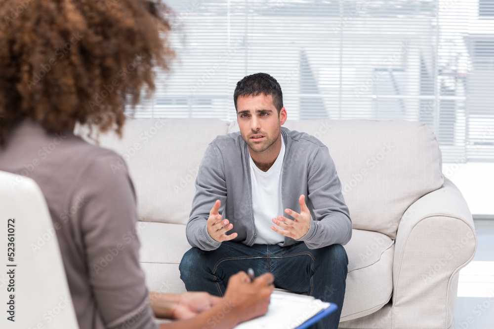 Depressed man speaking to a therapist Depressed man speaking to a therapist
