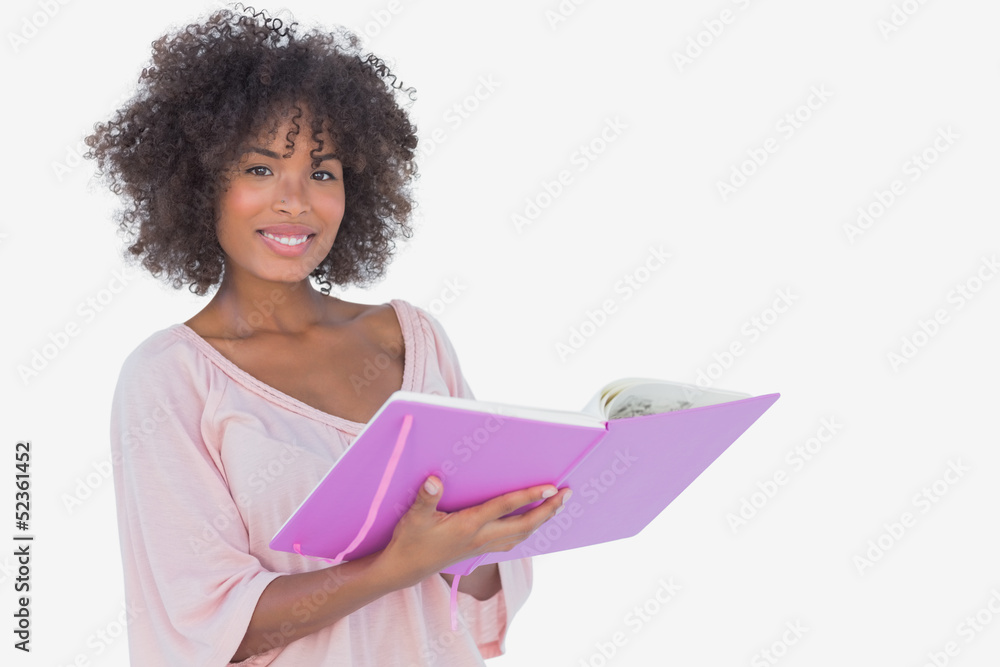 Beautiful woman holding photo album and smiling at camera