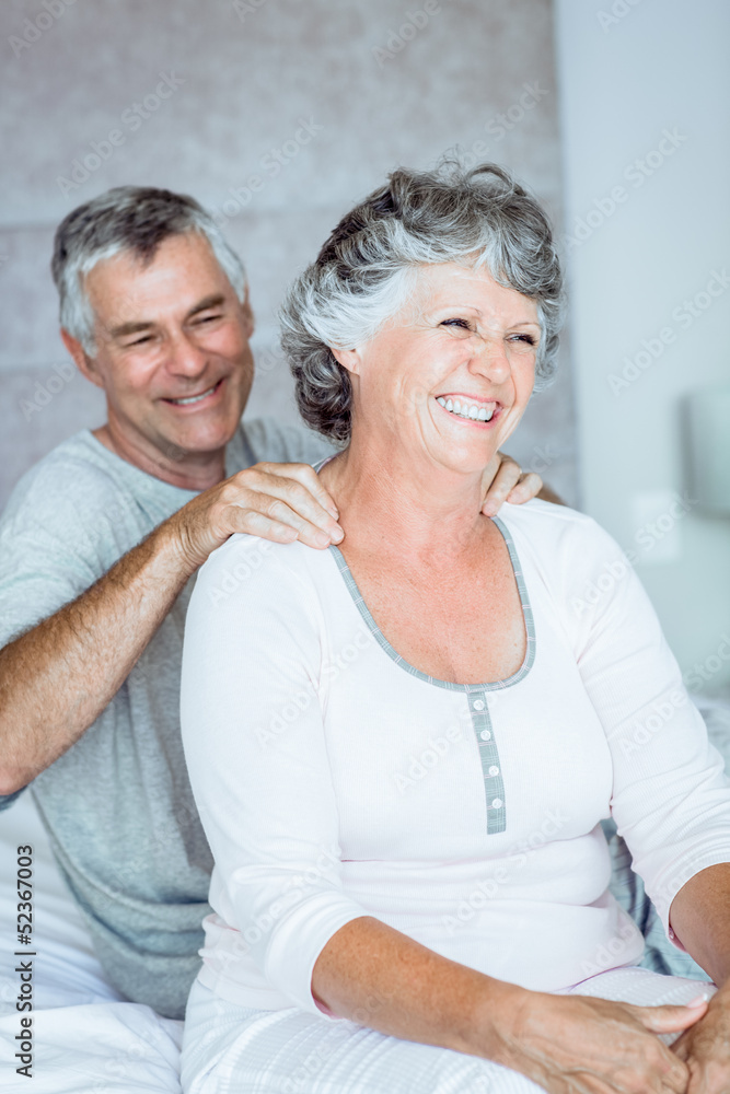 Mature man giving a shoulders massage to his wife Mature man giving a shoulders massage to his wife