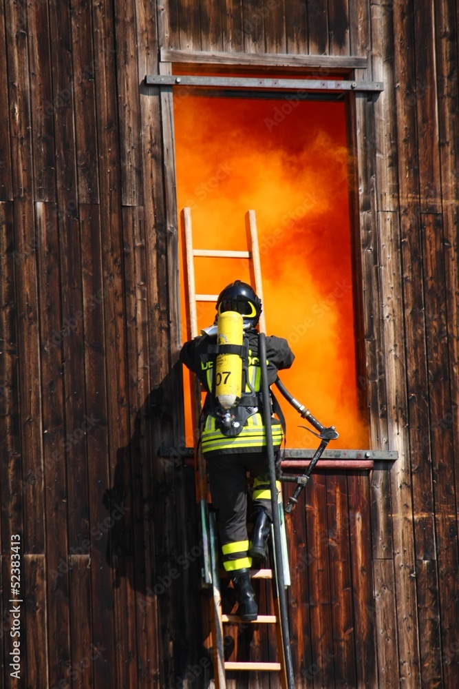 brave firefighters with oxygen cylinder goes into a house throug