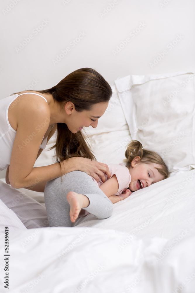 Mother and daughter playing on the bed Mother and daughter playing on the bed