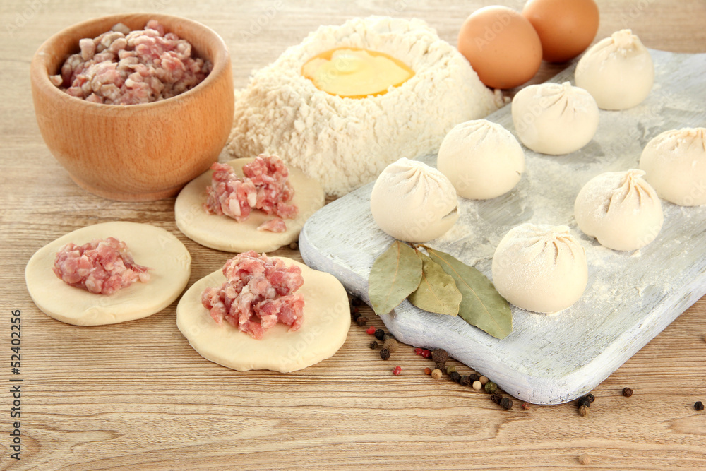 Raw dumplings, ingredients and dough, on wooden table