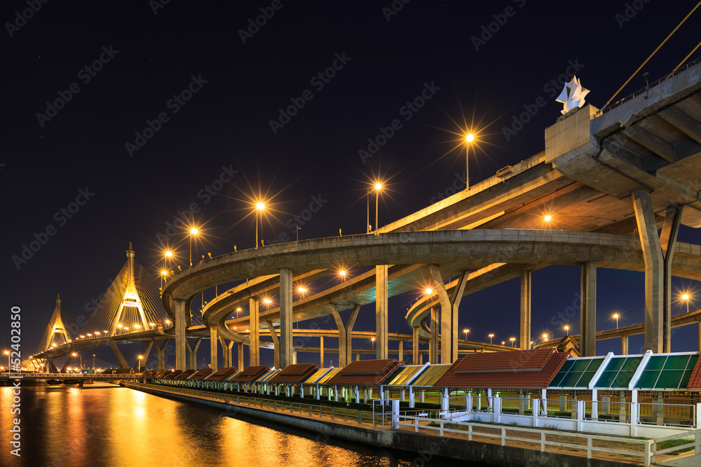 Obraz premium Curve of expressway by river in Bangkok at night