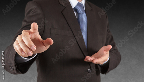 Businessman pressing an imaginary button on virtual screen