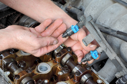 Mechanic fixing fuel injector, two camshaft car engine