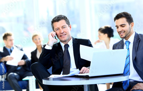 business man speaking on the phone while in a meeting