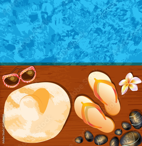 Flip-flops, hat, sunglasses and stones on the beach.