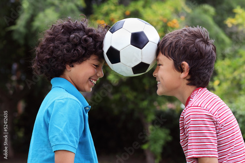 Two young boys playng with a soccer ball - close view © Nicholas B
