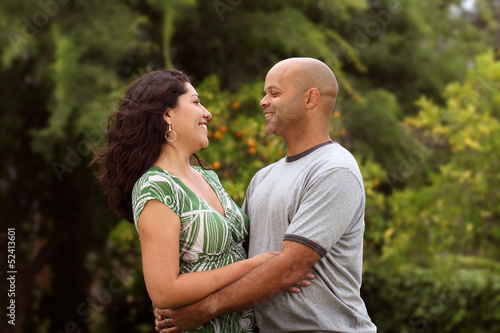 A happy mixed race couple relax outside