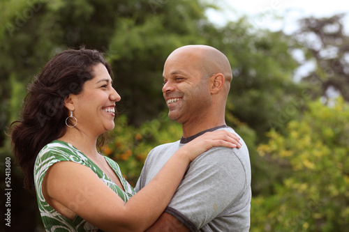 A happy mixed race couple relax outside - with copy space