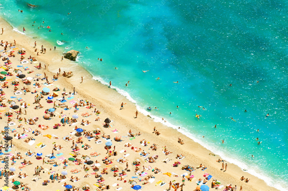 beach with tourists, sunbeds and umbrellas beach with tourists, sunbeds and umbrellas