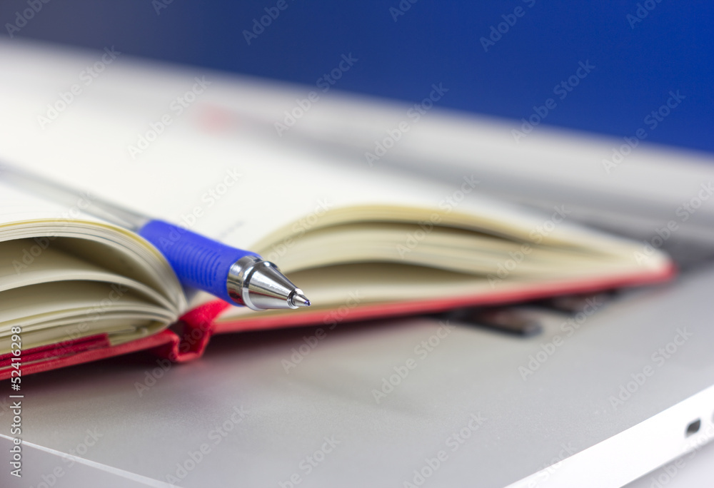 calendar or organizer or notebook and pen on the laptop calendar or organizer or notebook and pen on the laptop