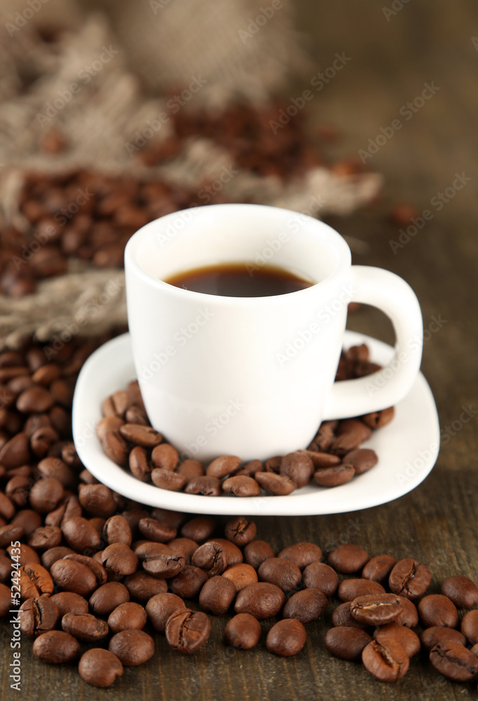 Cup of coffee and coffee beans on wooden background Cup of coffee and coffee beans on wooden background