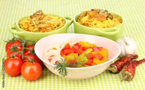 Delicious pilaf with vegetables on tablecloth background