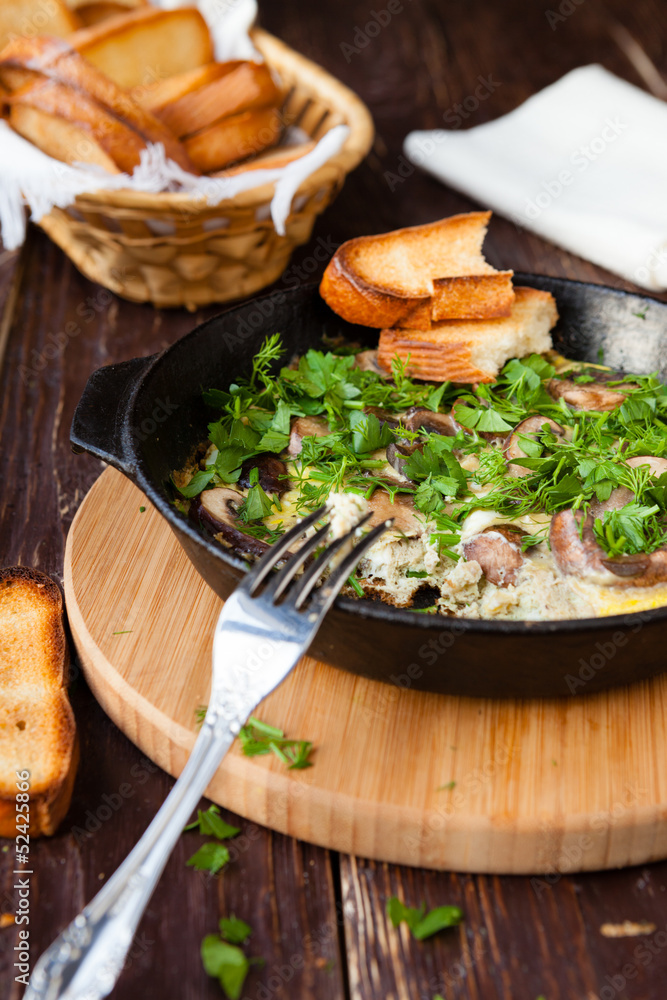 scrambled eggs with herbs and mushrooms in a pan