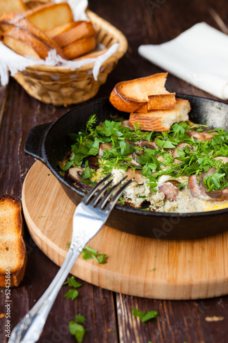 scrambled eggs with herbs and mushrooms in a pan