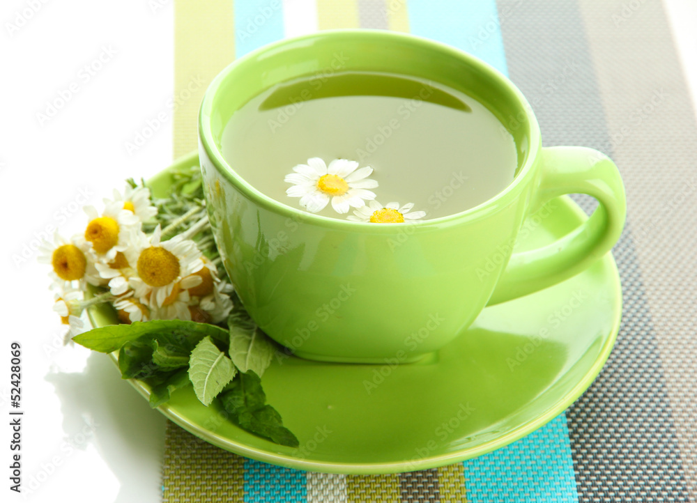 Cup of herbal tea with wild camomiles and mint, isolated Cup of herbal tea with wild camomiles and mint, isolated