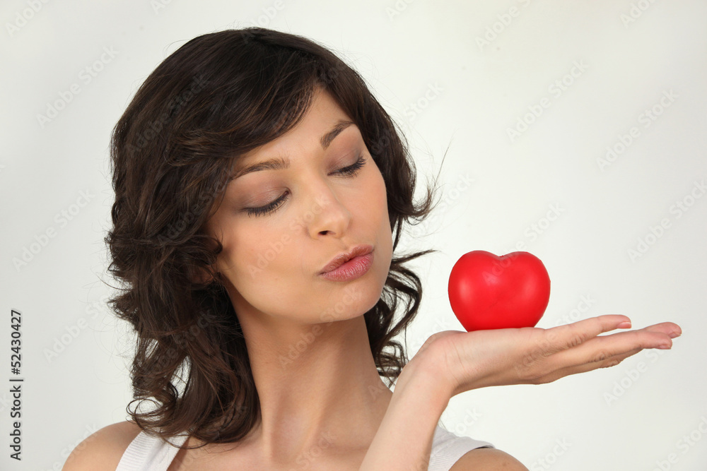 Woman with a heart laying on the palm of her hand Woman with a heart laying on the palm of her hand