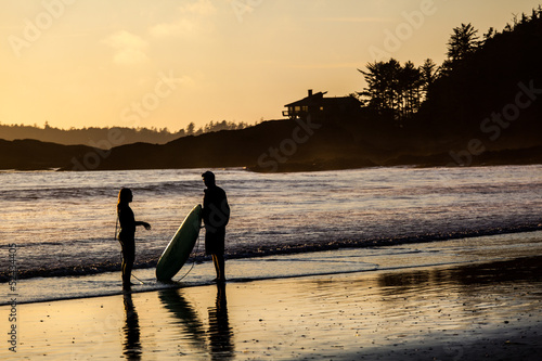 Couple of Surfers in Tofino Beach at Sunset Canada
