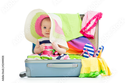 Baby girl sitting in suitca...