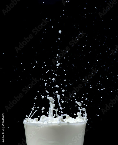 Splashing milk on black background
