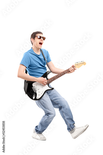 Full length portrait of a guy playing on an electric guitar