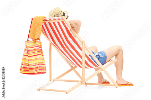 Canvas Print Young man enjoying on a beach chair
