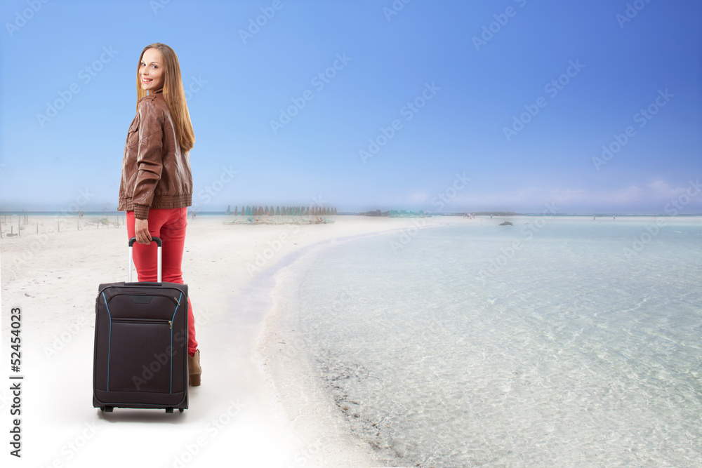 Fototapeta premium Woman with a suitcase on the beach