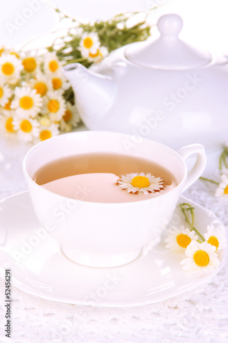 Cup of herbal tea with camomiles close up