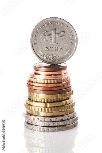 Fotografija A standing 1 kuna coin - Croatian currency - on top of the stack