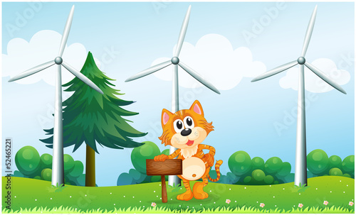 A tiger holding an empty wooden signboard near the windmills