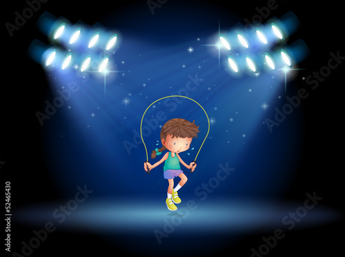 A girl playing jumping rope under the spotlights