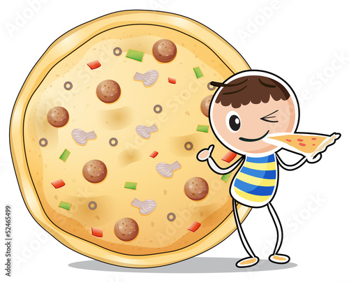 A boy beside a big pizza
