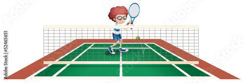 A boy playing tennis at the tennis court