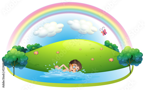A boy swimming in the river near the hill